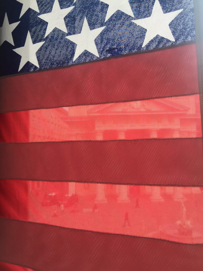The chamber of Commerce of Trieste seen through the American flag at Casa Bartoli